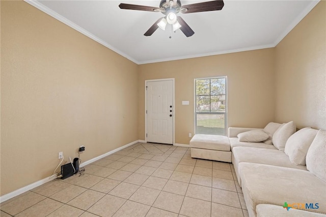 living area with light tile patterned floors, a ceiling fan, baseboards, and ornamental molding