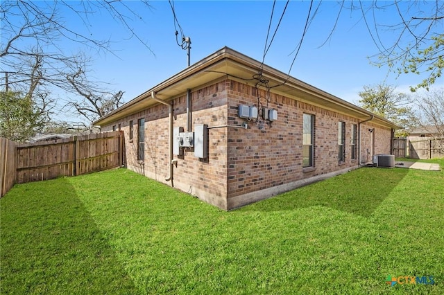 view of home's exterior with central air condition unit, a lawn, brick siding, and a fenced backyard