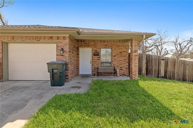 view of front facade with driveway, fence, an attached garage, a front yard, and brick siding