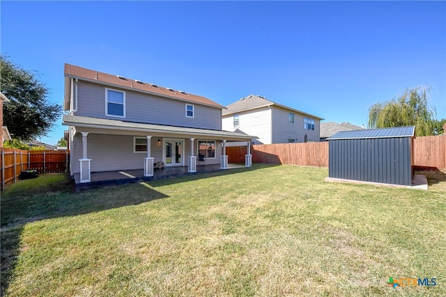 back of house featuring a yard and a storage unit