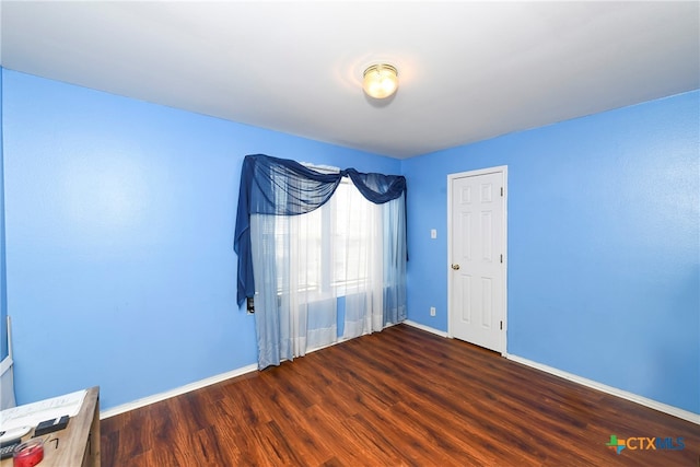 empty room with dark hardwood / wood-style flooring