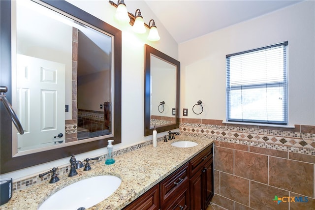 bathroom featuring vanity, tile walls, and lofted ceiling