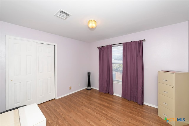 unfurnished bedroom featuring hardwood / wood-style floors and a closet