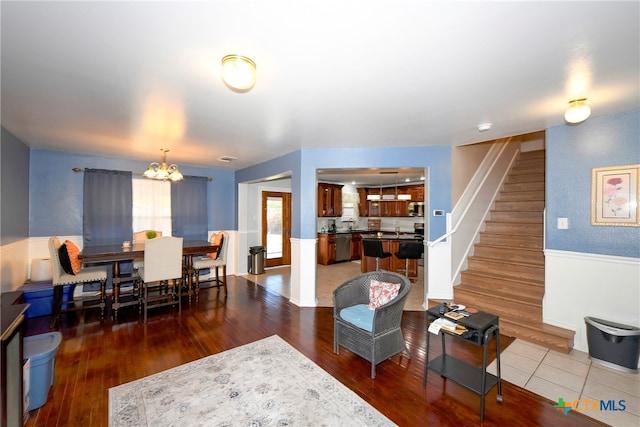 living room with dark hardwood / wood-style floors and an inviting chandelier