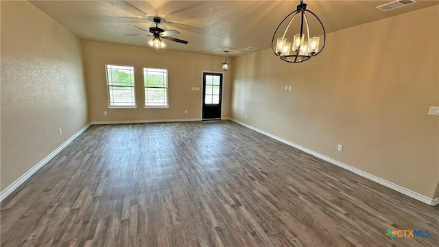 unfurnished room with ceiling fan with notable chandelier, visible vents, baseboards, and dark wood-type flooring
