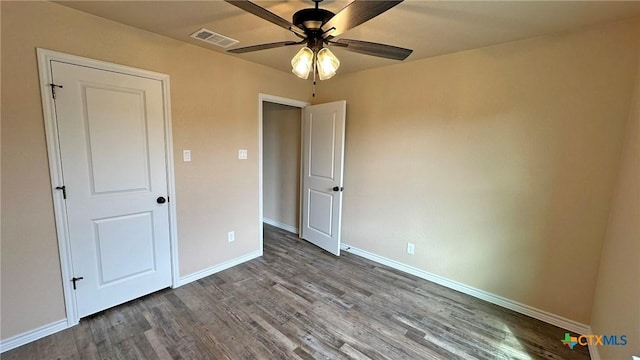 unfurnished bedroom with baseboards, visible vents, wood finished floors, and a ceiling fan