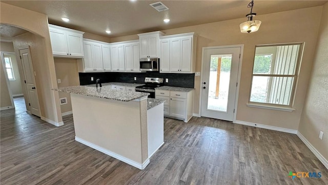 kitchen featuring white cabinets, visible vents, dark wood finished floors, arched walkways, and appliances with stainless steel finishes
