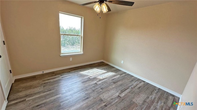 empty room featuring baseboards, wood finished floors, and a ceiling fan