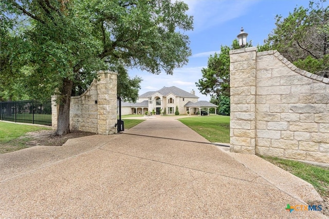 view of gate with a lawn