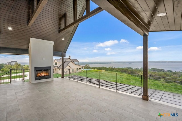 view of patio / terrace with a water view and a fireplace