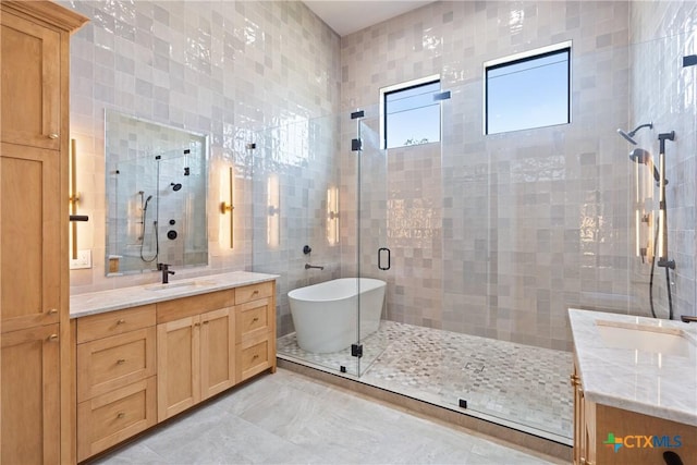 full bath featuring tile walls, a soaking tub, vanity, and a shower stall