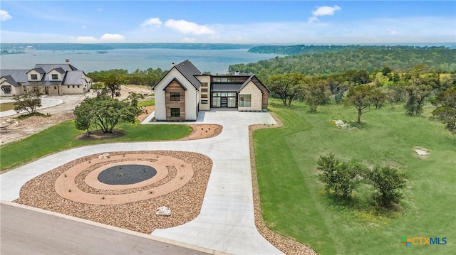 exterior space with curved driveway and a water view