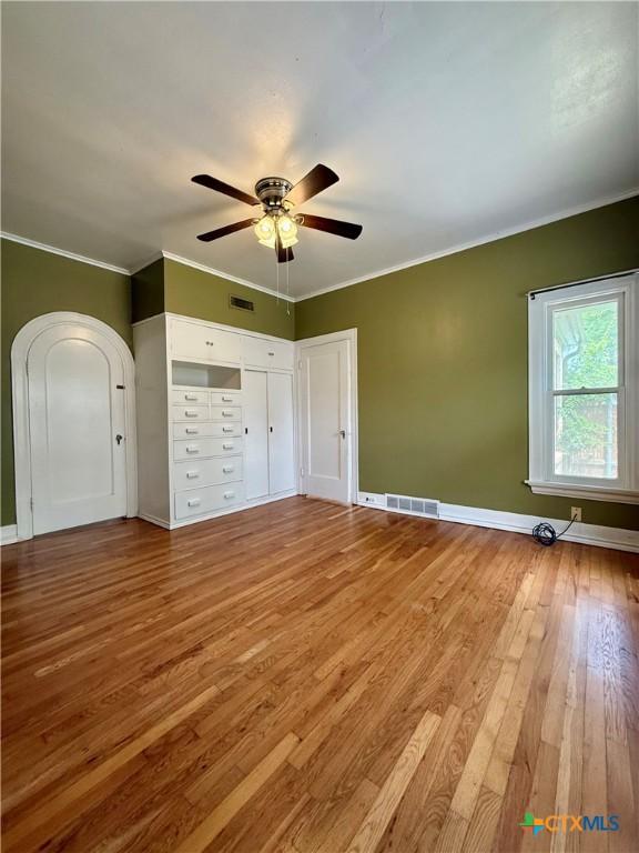 1500 N 5th St, Temple, TX 76501 - unfurnished bedroom featuring light wood-type flooring, baseboards, crown molding, and ceiling fan