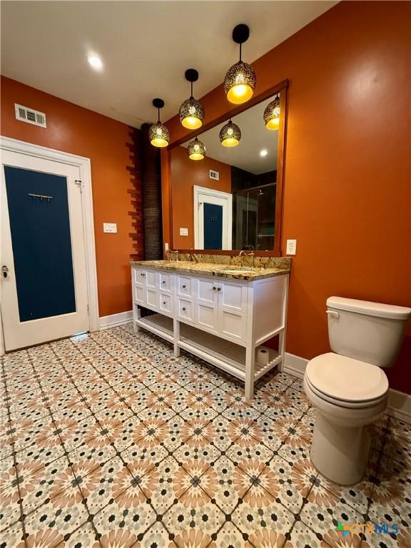 1500 N 5th St, Temple, TX 76501 - bathroom with baseboards, double vanity, and toilet