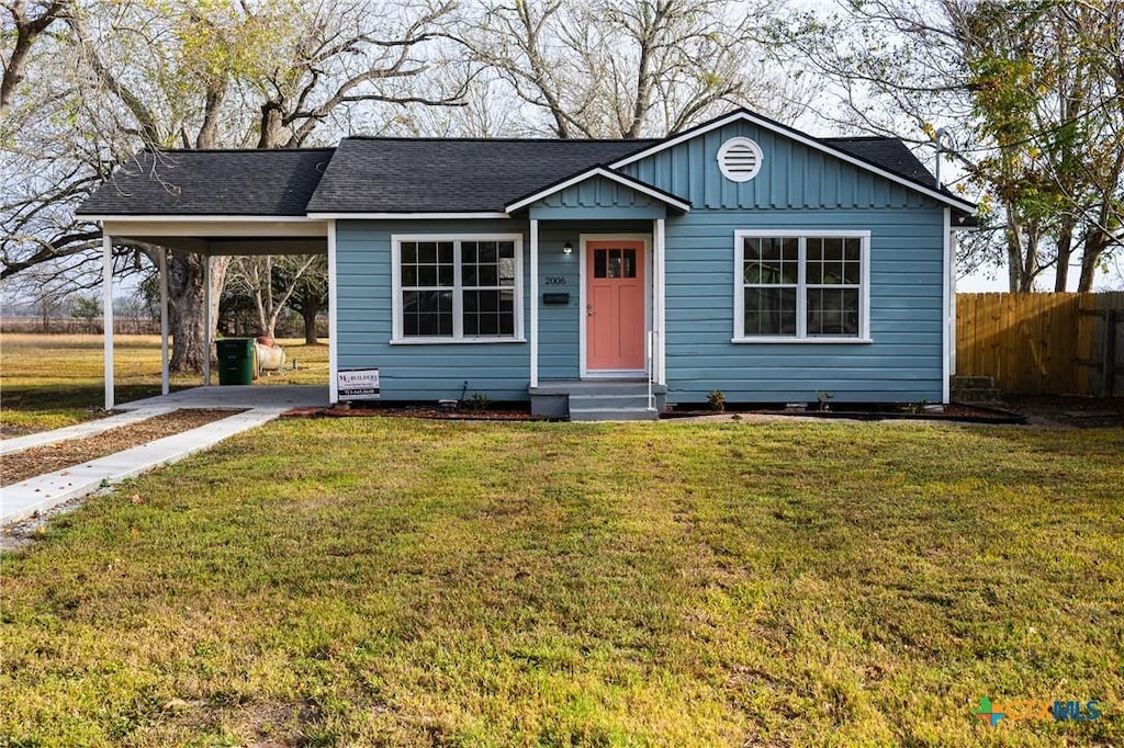 view of front of property with a front yard and a carport