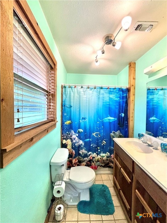 bathroom with vanity, a textured ceiling, curtained shower, tile patterned floors, and toilet