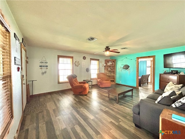 living room featuring wood-type flooring, a barn door, and ceiling fan