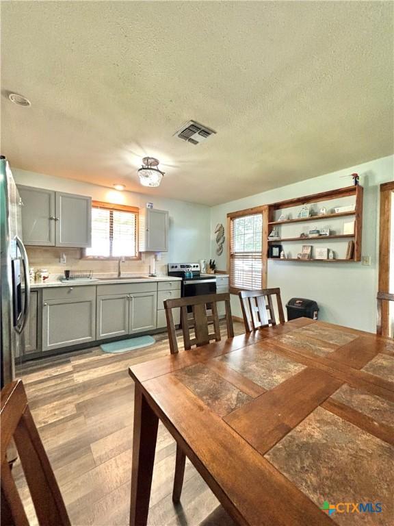 interior space with sink, a textured ceiling, and light hardwood / wood-style flooring