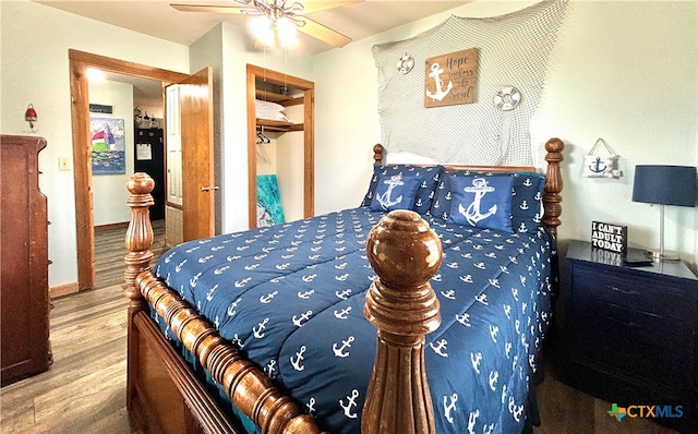 bedroom featuring hardwood / wood-style flooring, a closet, ceiling fan, and a spacious closet