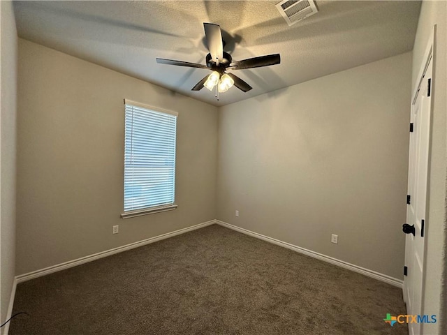 unfurnished room with dark colored carpet and ceiling fan