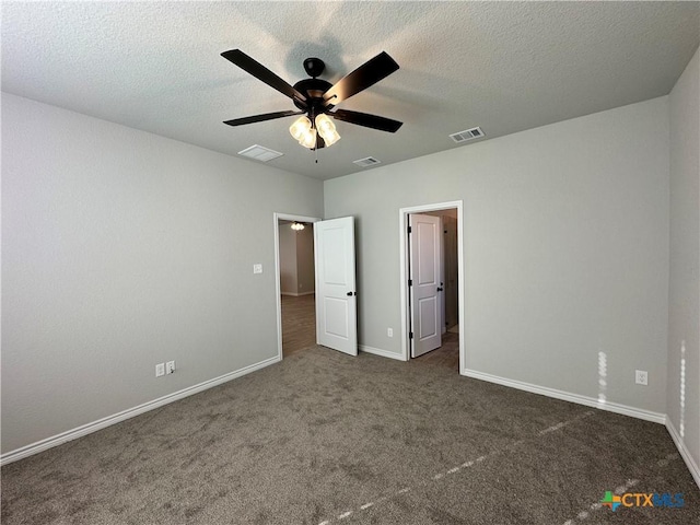 unfurnished bedroom with ceiling fan, a textured ceiling, and dark colored carpet