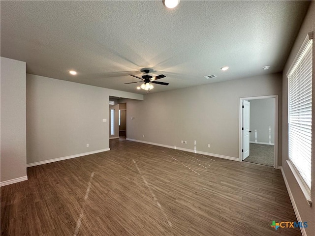 empty room featuring ceiling fan, dark hardwood / wood-style floors, and a textured ceiling