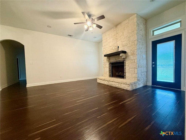 unfurnished living room featuring ceiling fan, a fireplace, and dark wood-type flooring