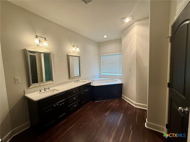 bathroom featuring wood-type flooring, vanity, and a bathing tub