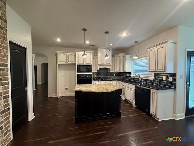 kitchen featuring tasteful backsplash, pendant lighting, a kitchen island, and black appliances