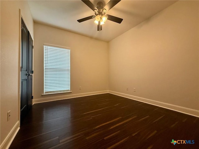 spare room with ceiling fan and dark wood-type flooring