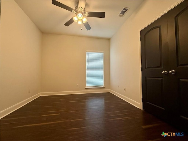 spare room featuring dark hardwood / wood-style floors and ceiling fan