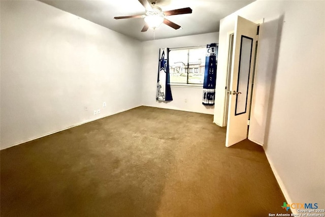 spare room with ceiling fan and carpet