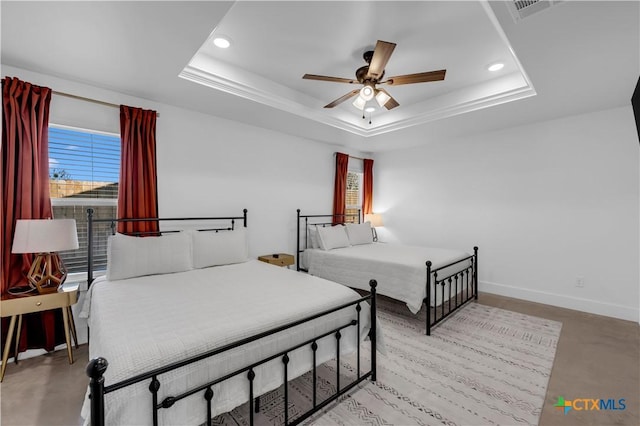 bedroom featuring a raised ceiling and ceiling fan