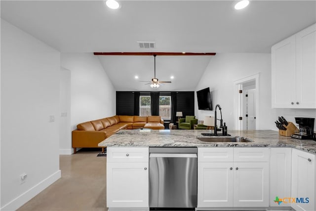 kitchen with kitchen peninsula, sink, light stone countertops, and white cabinets