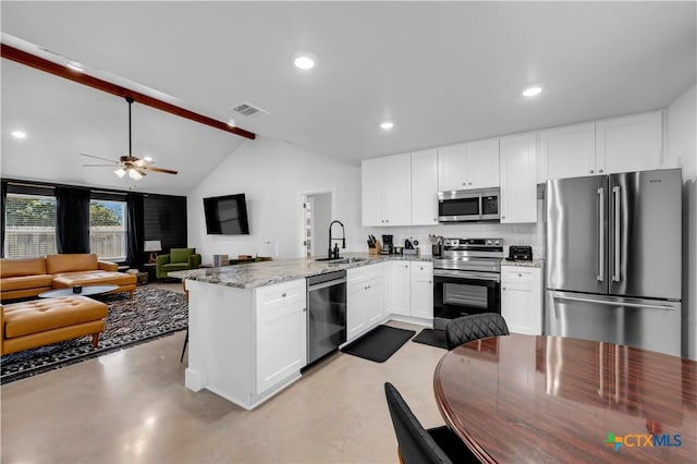 kitchen featuring sink, stainless steel appliances, tasteful backsplash, white cabinets, and kitchen peninsula