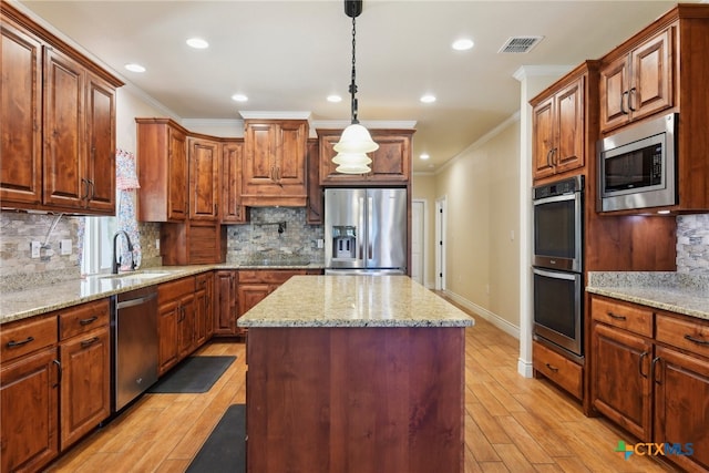 kitchen featuring appliances with stainless steel finishes, tasteful backsplash, sink, light hardwood / wood-style floors, and a kitchen island