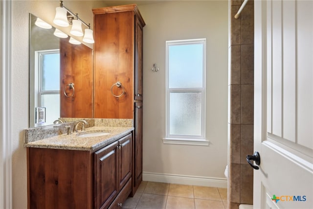 bathroom with tile patterned flooring, vanity, and a healthy amount of sunlight