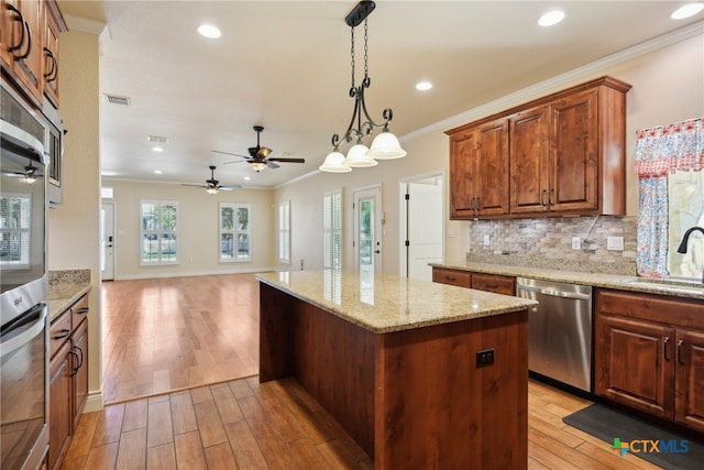 kitchen featuring backsplash, stainless steel appliances, crown molding, sink, and light hardwood / wood-style floors