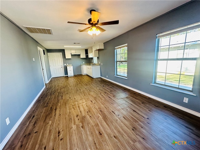 unfurnished living room featuring ceiling fan, light wood-type flooring, and sink