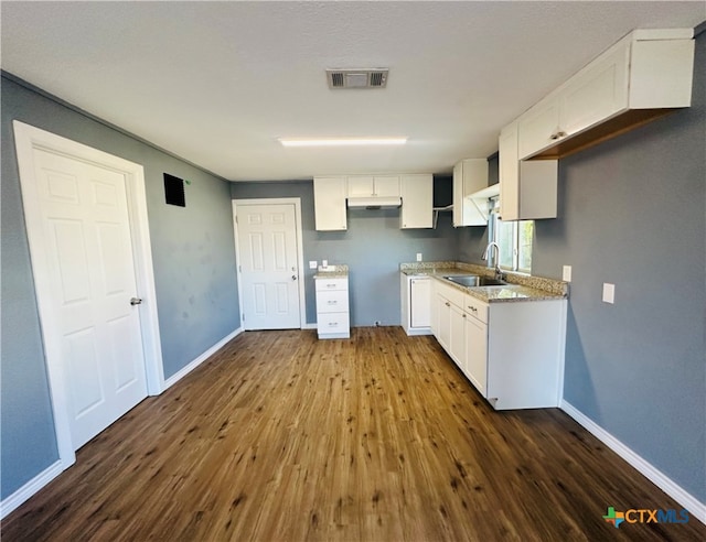 kitchen with dark hardwood / wood-style flooring, sink, and white cabinets