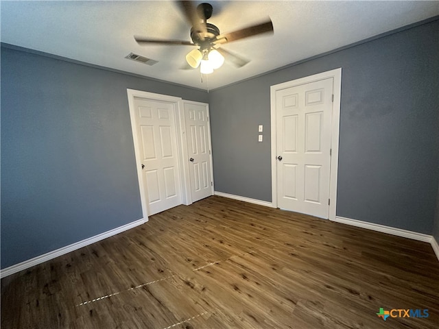 unfurnished bedroom with ceiling fan and dark hardwood / wood-style floors