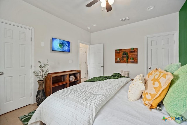 bedroom featuring light tile patterned floors, visible vents, and a ceiling fan