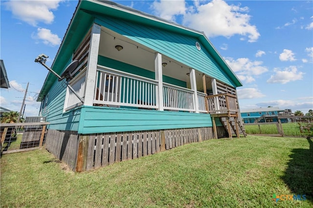 view of home's exterior with stairway, a yard, and fence