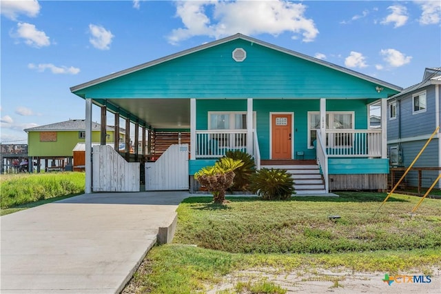 view of front of house featuring a carport, a porch, driveway, and a front lawn