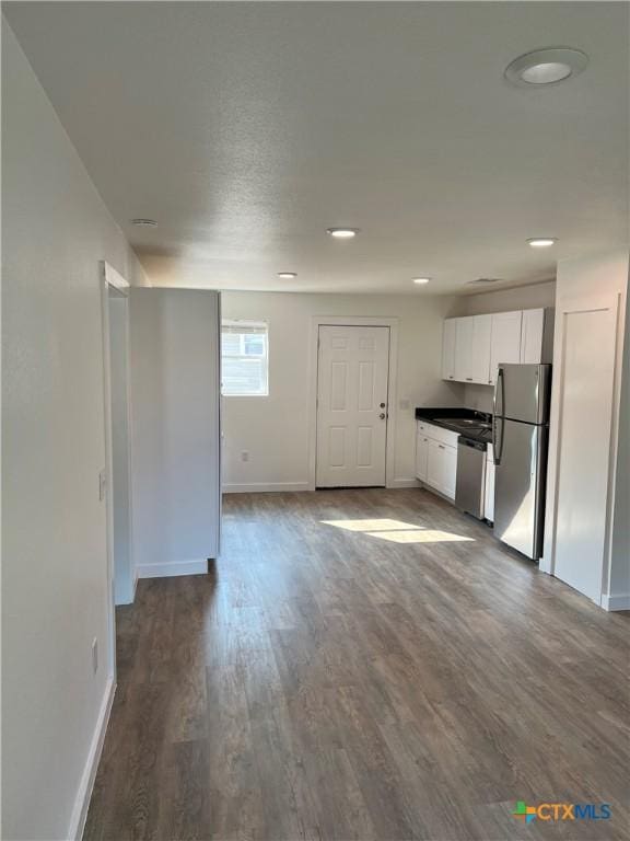 kitchen with white cabinetry, stainless steel appliances, and hardwood / wood-style flooring