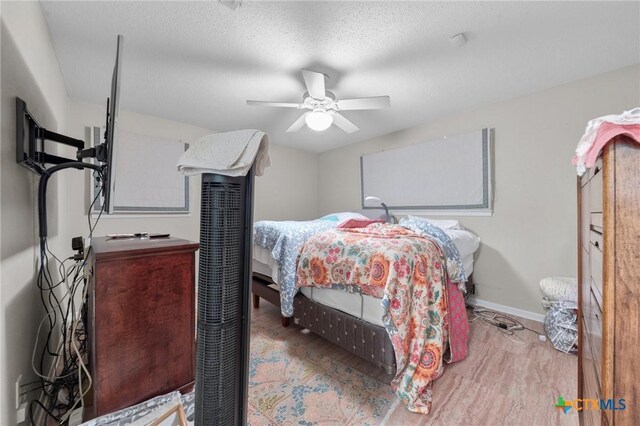 bedroom featuring a ceiling fan, baseboards, and wood finished floors