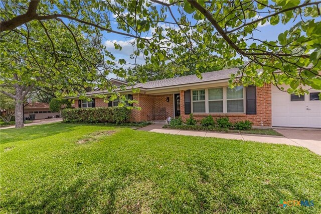 single story home featuring brick siding, a front yard, and a garage