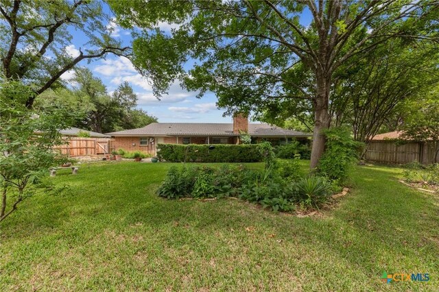 view of yard with a gate and a fenced backyard