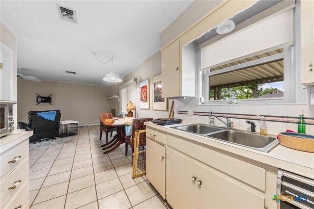 kitchen with a sink, light countertops, open floor plan, light tile patterned floors, and visible vents