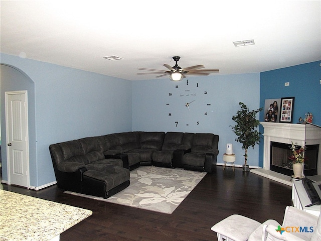 living room featuring ceiling fan and dark hardwood / wood-style flooring